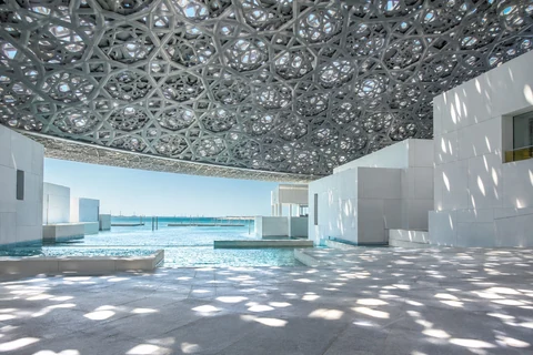 Mưa ánh sáng xuyên mái vòm hình học Louvre Abu Dhabi bên mặt nước